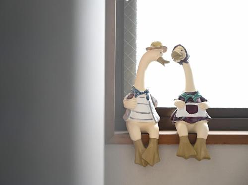 two figurines of two people sitting on a window sill at Two bathrooms, two toilets 6 mins walking distance from Keisei Takasago Station in Tokyo