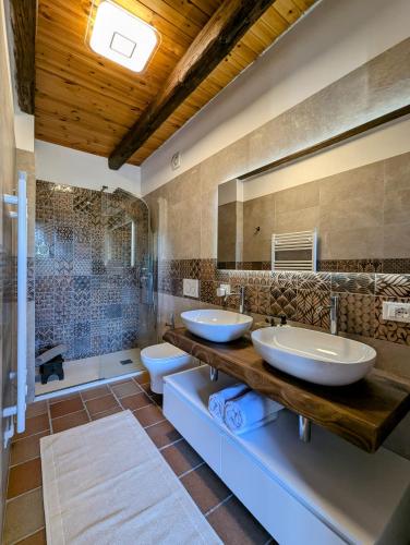 a bathroom with two sinks and a large mirror at Libero Ranch in Paderno