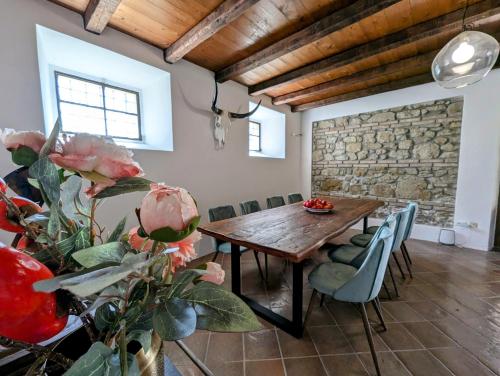una sala da pranzo con tavolo in legno e parete in pietra di Libero Ranch 