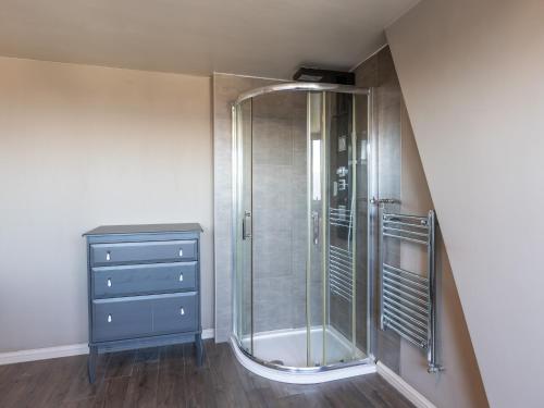 a bathroom with a shower and a blue dresser at Holiday home for 6 people with garden in Middelkerke