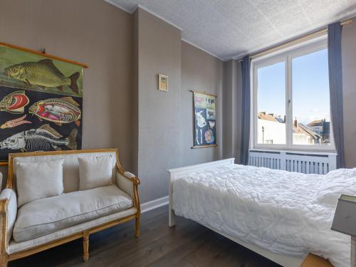 a bedroom with a bed and a chair and a window at Holiday home for 6 people with garden in Middelkerke
