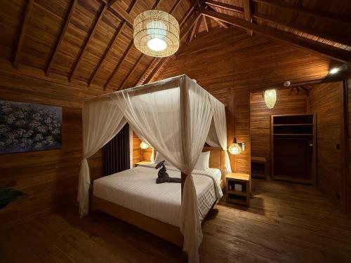 a bedroom with a bed with a canopy at Taman Swarga Villa Resort & Spa Sidemen in Sidemen