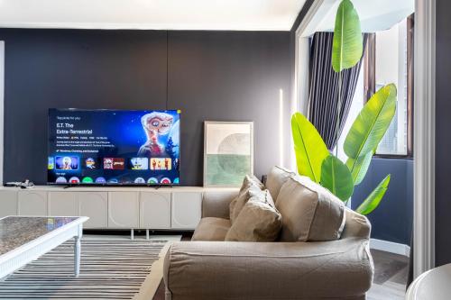 ein Wohnzimmer mit Sofa und Fernseher in der Unterkunft Omni Nuvél 4 Sukhumvit Branded Suites in Bangkok