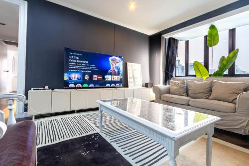 ein Wohnzimmer mit Sofa und Tisch in der Unterkunft Omni Nuvél 4 Sukhumvit Branded Suites in Bangkok