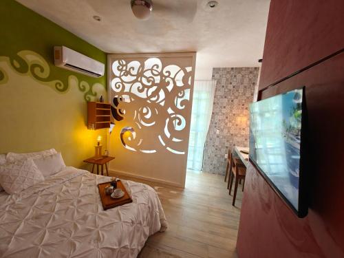 a bedroom with a bed and a flat screen tv at Tu Departamento en Mahahual in Mahahual