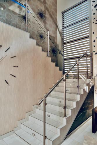 a staircase in a house with white stairs and a glass wall at Escapade Lux Guesthouse in Gaborone