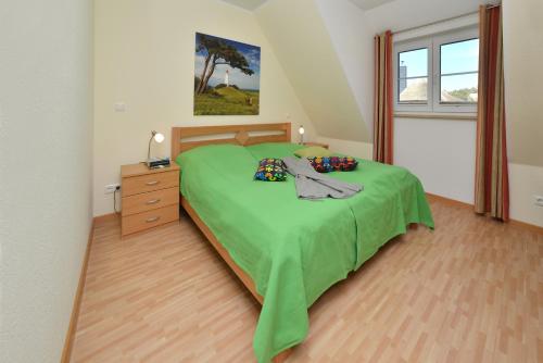 una camera con letto verde, cassettiera e finestra di Ferienwohnung Generalsuite a Breege