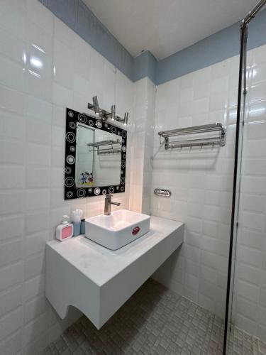 a white bathroom with a sink and a mirror at SnS Muine Homestay in Mui Ne