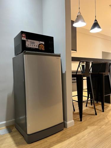 a refrigerator with a box on top of it next to a table at AGROWTH at Aru Suites in Kota Kinabalu