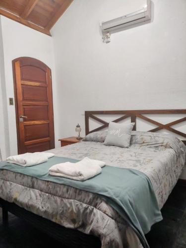 a bedroom with a bed with two towels on it at Cabaña Lodge Araucaria ll in Eduardo Castex