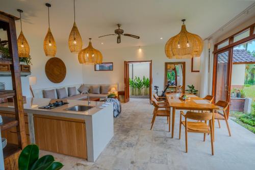 a kitchen and dining room with a table and chairs at Prana Eco Wooden Villa in Ubud
