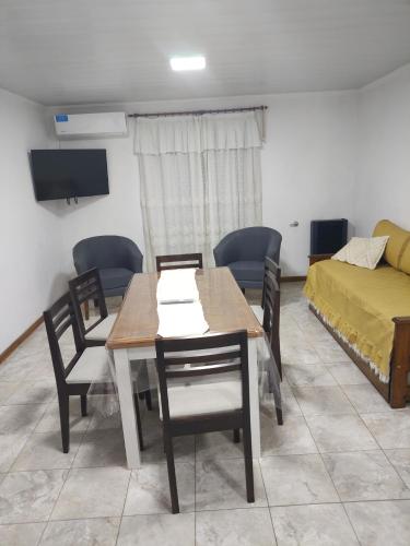 ein Esszimmer mit Tisch und Stühlen und einem Bett in der Unterkunft Lodge Araucaria Apartamento por día in Eduardo Castex