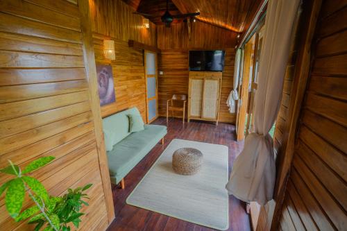 a living room with a couch and a table at Prana Eco Wooden Villa in Ubud