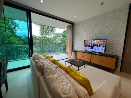 a living room with a large couch and a tv at InterContinental Khao Yai Condo with 2Bedrooms, 2Bathrooms plus 3 bicycles Free in Pong Talong