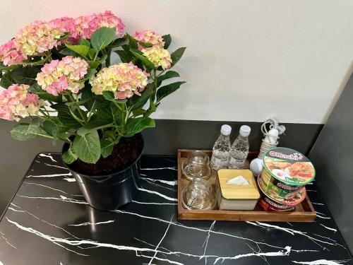 a vase with pink flowers on a table with a tray at Ruby Star Hotel Nam Quoc Cang in Ho Chi Minh City