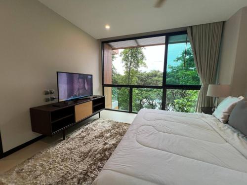 a bedroom with a large bed and a flat screen tv at InterContinental Khao Yai Condo with 2Bedrooms, 2Bathrooms plus 3 bicycles Free in Pong Talong