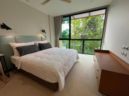 a bedroom with a bed and a large window at InterContinental Khao Yai Condo with 2Bedrooms, 2Bathrooms plus 3 bicycles Free in Pong Talong