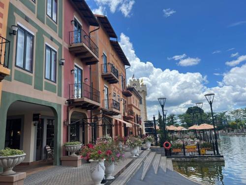 a row of buildings next to a canal with flowers at InterContinental Khao Yai Condo with 2Bedrooms, 2Bathrooms plus 3 bicycles Free in Pong Talong