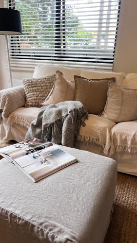 a living room with a couch and a book on a table at Coastal Drift - Iluka -Apartment 2 - No Pets Allowed in Iluka