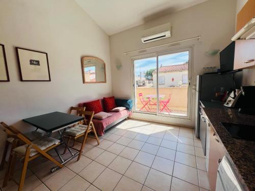 un salon avec un canapé et une table dans l'établissement Argelès-sur-Mer - T2 Cabine Meublé avec Clim et Terrasse à 50m de la Plage - FR-1-309-172, à Argelès-sur-Mer
