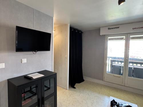 un salon avec une télévision à écran plat au mur dans l'établissement Appartement charmant proche plage et commerces - FR-1-712-13, à Villers-sur-Mer