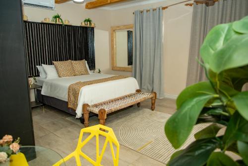 a bedroom with a bed and a bench in it at Kanana Villas-Maun Luxury Studio Suite in Maun