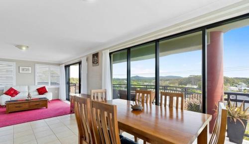 a dining room with a table and a couch at Sea breeze in Nambucca Heads