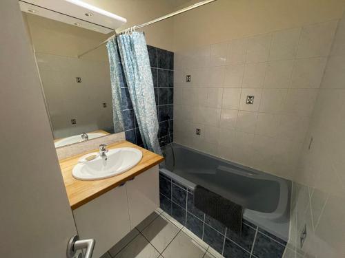 une salle de bain avec un lavabo et une baignoire dans l'établissement T2 avec terrasse, 500m de la plage, Les Sables-d'Olonne - FR-1-92-896, à Les Sables-dʼOlonne