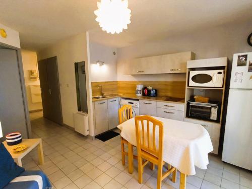 Il comprend une cuisine équipée d'une table et de chaises. dans l'établissement Confortable T2 rénové avec terrasse vue mer à Sète - FR-1-472A-316, à Sète