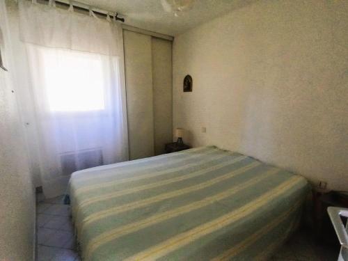 un lit dans une chambre avec une fenêtre dans l'établissement Confortable T2 rénové avec terrasse vue mer à Sète - FR-1-472A-316, à Sète