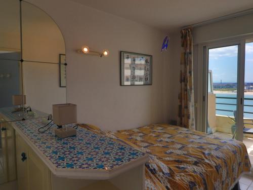 une chambre avec un lit et une grande fenêtre dans l'établissement T2 cab en résidence avec piscine à la plage et terrasse à Sète - FR-1-472A-315, à Sète