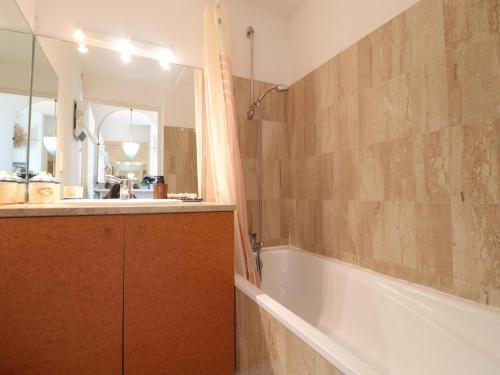 une salle de bain avec une baignoire et un lavabo dans l'établissement T2 cab en résidence avec piscine à la plage et terrasse à Sète - FR-1-472A-315, à Sète