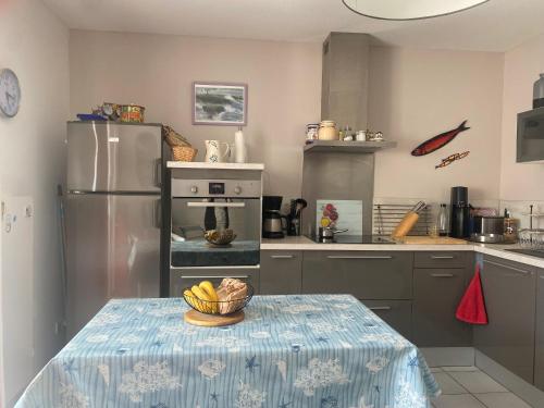 - une cuisine avec une table et un bol de bananes dans l'établissement Maison proche centre pour 4 personnes - FR-1-22-385, à La Tranche-sur-Mer