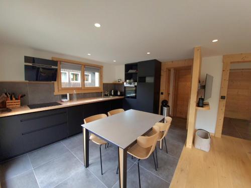 une cuisine avec une table et des chaises dans une pièce dans l'établissement Bel appartement T3, centre village, proche pistes, parking - FR-1-459-244, à La Clusaz