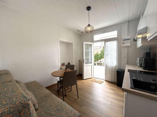 Cette chambre comprend un lit, une table et une cuisine. dans l'établissement Charmante maison 2 pièces à Saint-Gilles-Croix-de-Vie - FR-1-224-818, à Saint-Gilles-Croix-de-Vie