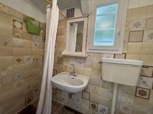 une petite salle de bain avec un lavabo et une fenêtre dans l'établissement Charmante maison 2 pièces à Saint-Gilles-Croix-de-Vie - FR-1-224-818, à Saint-Gilles-Croix-de-Vie