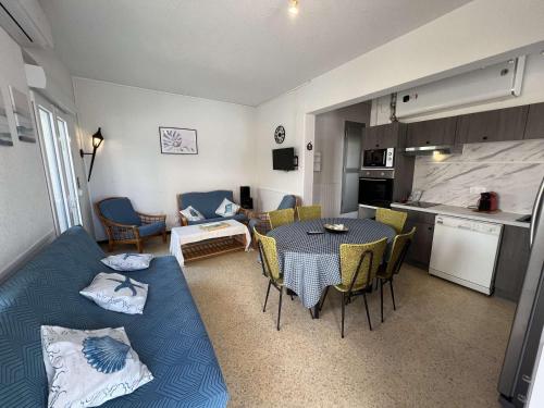un salon avec un canapé bleu et une table dans l'établissement Pavillon T3 en bord de mer avec accès plage pour 4 personnes - FR-1-701-93, à Valras-Plage