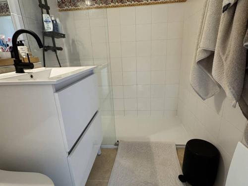 une salle de bain blanche avec un lavabo et une douche dans l'établissement Maison rénovée 2 chambres, terrasse vue mer - FR-1-726-63, à La Croix-Valmer