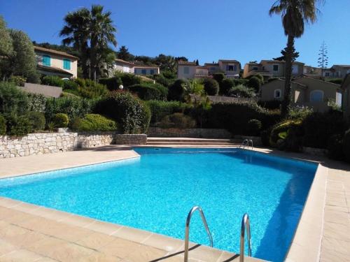 - une piscine dans une cour avec des arbres et des maisons dans l'établissement Maison rénovée 2 chambres, terrasse vue mer - FR-1-726-63, à La Croix-Valmer