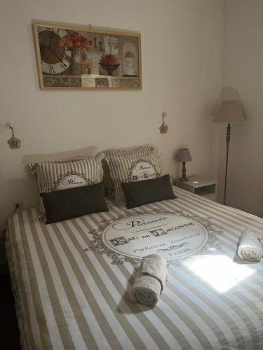 - un lit avec des draps rayés et des oreillers dans l'établissement Maison de la Gargoyle, à Pézenas