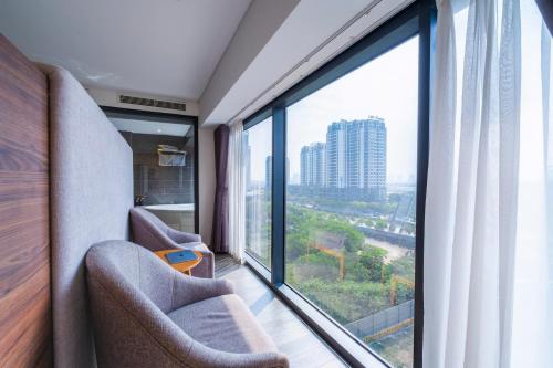 a room with two chairs and a large window at Luxury Pentstudio Westlake - Tay Ho, Ha Noi in Hanoi