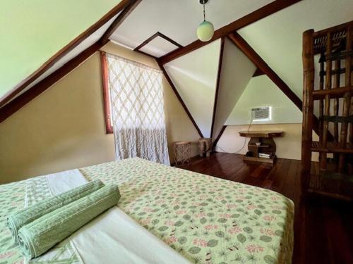 a bedroom with a bed in a attic at Villa Barnes Siargao in General Luna