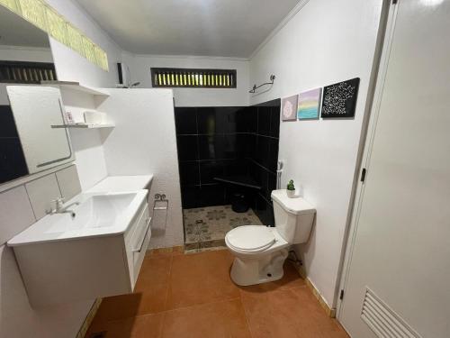 a bathroom with a white toilet and a sink at Villa Barnes Siargao in General Luna