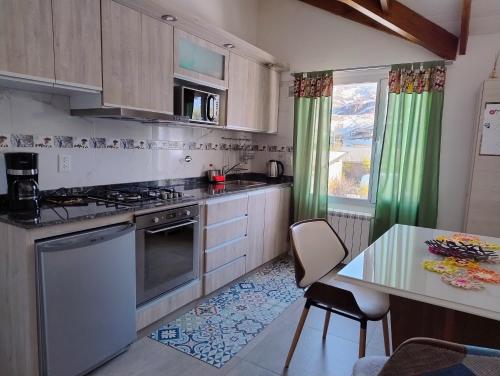 cocina con fogones y mesa con sillas en Apart Ruta 40, en El Chaltén