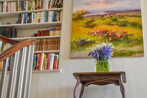 アイルシャムにあるSankence lodge B&Bの本棚の横のテーブルの花瓶