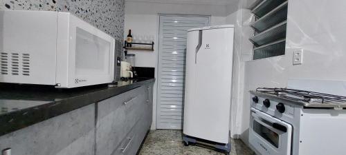 una cucina con un frigorifero bianco e una stufa di Suites Essepê! Expo center norte, Anhembi, Rodoviaria Tiete, Templo Salomao e Vautier a San Paolo