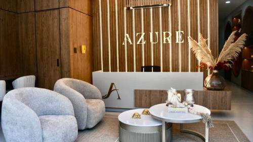 a lobby with two chairs and a table and a sign at Azure apartahotel in Santa Marta