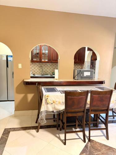 a kitchen with a table with chairs and a sink at White House by White River in Ocho Rios