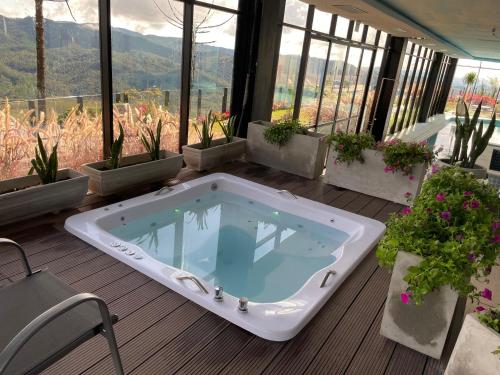 a jacuzzi tub sitting on a deck with plants at Gran Paradiso Campos do Jordão - Resort in Campos do Jordão