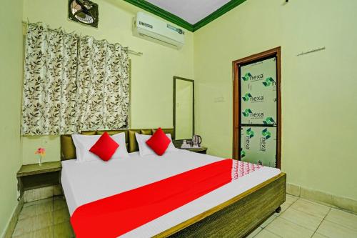 een slaapkamer met een groot bed met rode kussens bij Hotel O B N Palace in Raipur